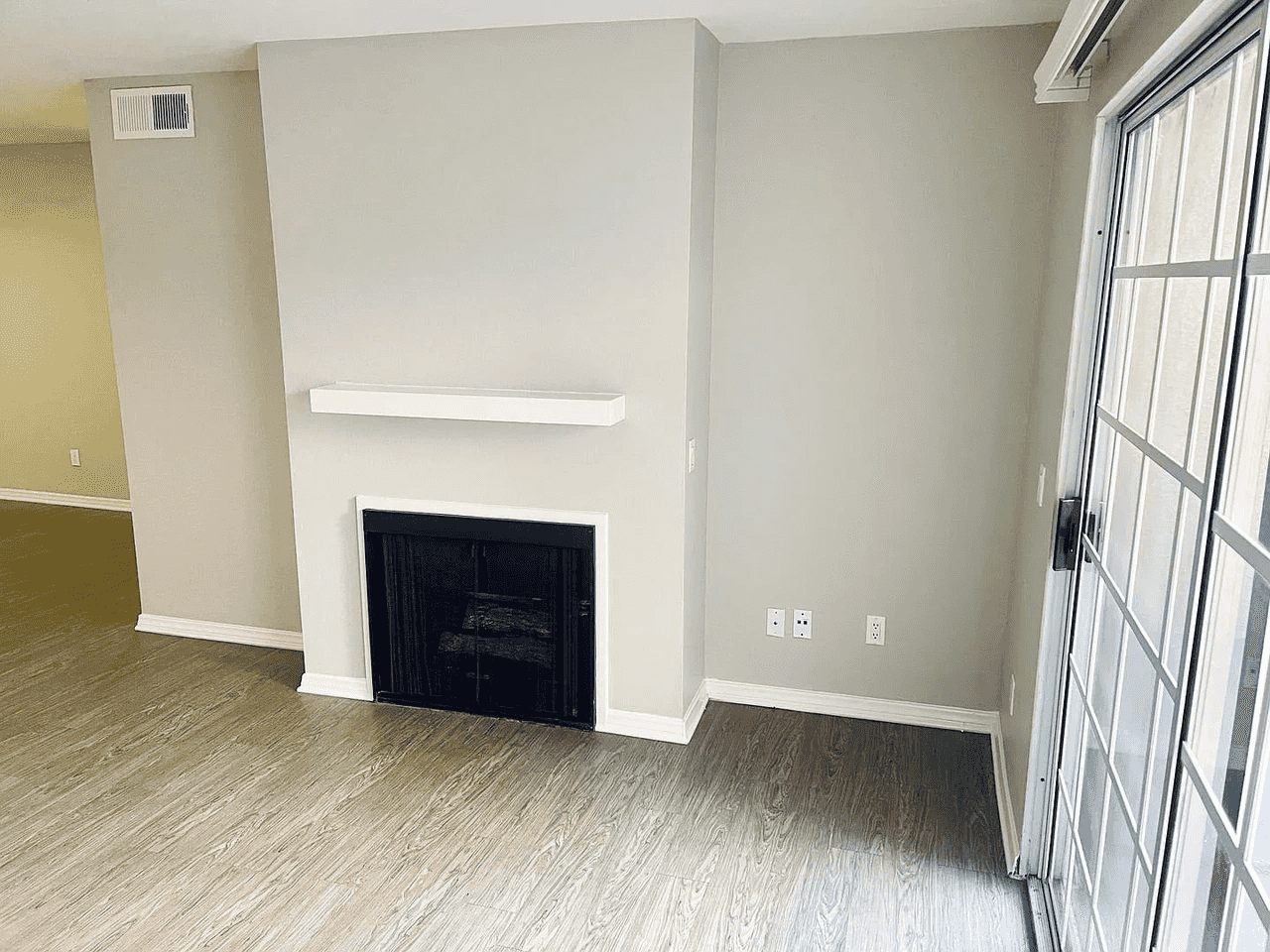 fireplace detail with white mantel and wood style flooring