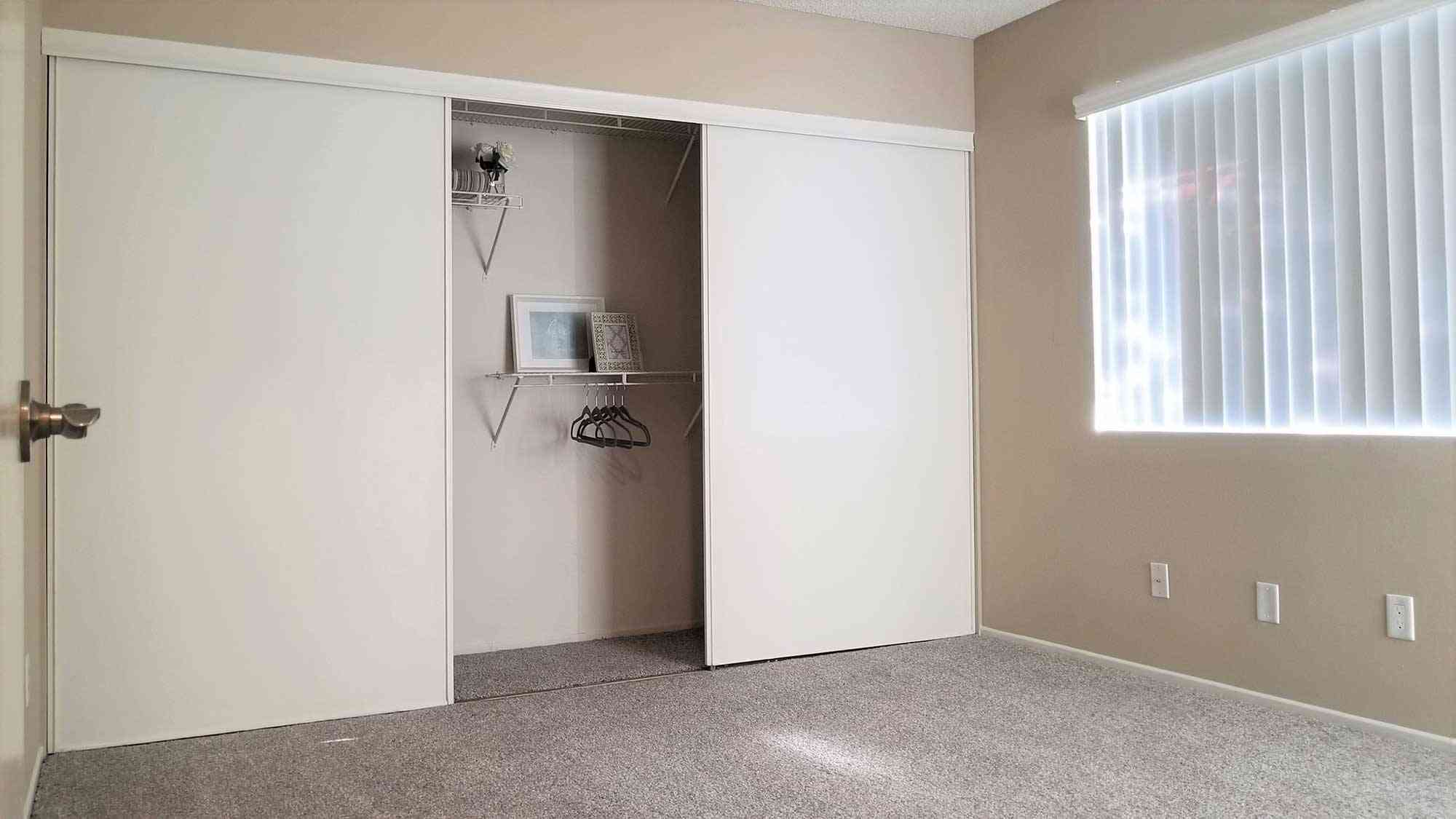 bright bedroom with sliding closet doors and window